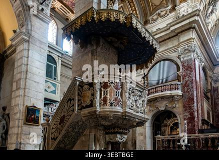 Eine verzierte Marmorkanzel in der Kathedrale Santa Maria in Cagliari. Das Innere ist mit Skulpturendetails, einer Orgel und hohen Steinbögen ausgestattet. Stockfoto
