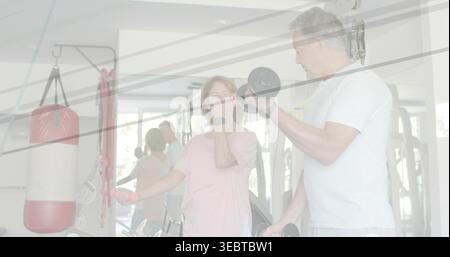 Schwerere Kurzhantel heben, reifes Paar lockert kleinere Kurzhantel im Fitnessstudio in leichter Trainingskleidung Stockfoto