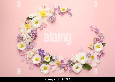 Rahmen aus vielen verschiedenen Blumen auf rosafarbenem Hintergrund, flach gelegt. Leerzeichen für Text Stockfoto