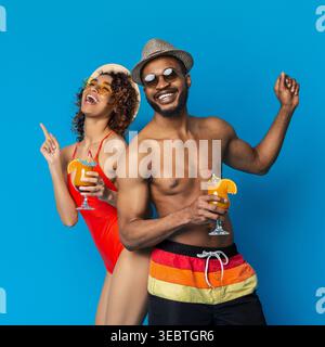 Zwei Personen feiern den Sommer auf spielerische Art und Weise mit bunten Getränken Stockfoto