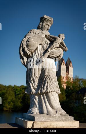 Historische Nepomuk-Statue auf der Alten Lahnbrücke in Limburg, Deutschland. Mit dem Limburger Dom im Hintergrund. Christliche Kunst und Architektur Stockfoto