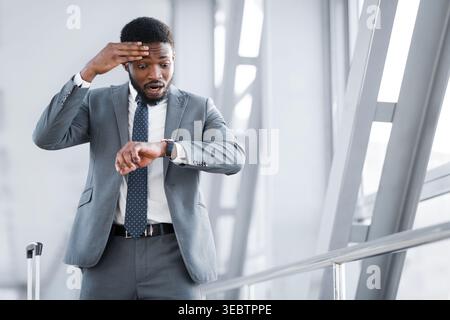 Flug. Geschäftsmann an Watch am Flughafen suchen Stockfoto