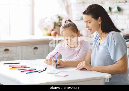 Mutter und Tochter genießen gemeinsam Kunst und Kunsthandwerk zu Hause in einer hellen Küche Stockfoto