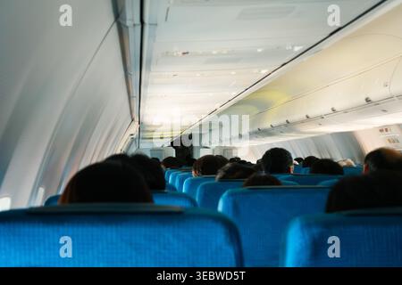 Passagiere, die in der Kabine der Economy Class sitzen Stockfoto