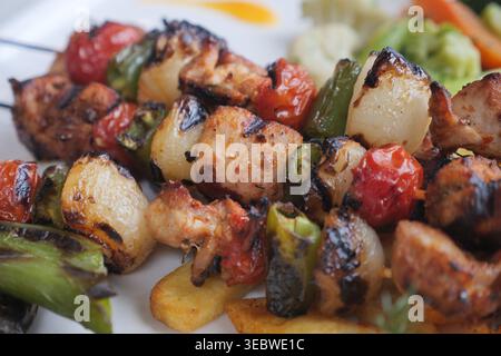 Gegrillte Fleisch- und Gemüsespieße auf einem Teller Stockfoto