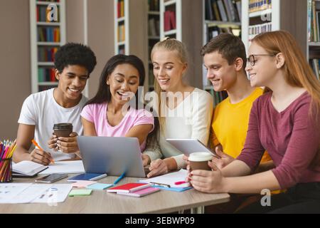 Gruppe von Studenten, die am Nachmittag an einem Projekt in einer Bibliothek zusammenarbeiten Stockfoto