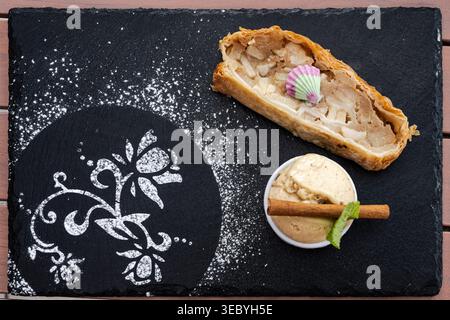 Veganer, pflanzlicher Apfelstrudel mit Eis Dessert auf Schieferbrett Gourmet Stockfoto