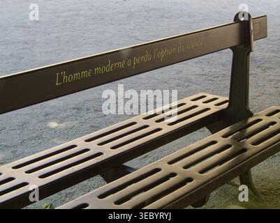 Eine Bank im Jardin du Palais Royal, Paris, Frankreich. Die Inschrift auf Französisch lautet "L'homme moderne a perdu l'option du silencie". Stockfoto