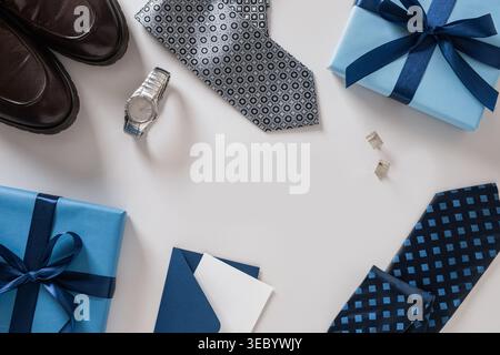 Vatertag-Geschenk-Konzept mit Krawattenschuhen Uhr Manschettenknöpfe und blaue Geschenkbox auf hellem Hintergrund, stilvolle Männer Accessoires Komposition, Kopierraum, Top-Wettbewerb Stockfoto