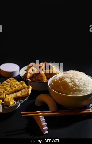 Leckeres chinesisches Essen und Essstäbchen auf dunklem Hintergrund Stockfoto