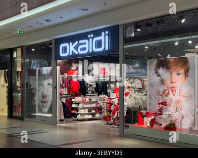 Krakau, Polen - 3. Dezember 2025: Vorderansicht des Eingangs des Okaidi Kindermode-Geschäfts mit Regalen mit saisonaler Mode, Schaufensterpuppen und Promotion Stockfoto