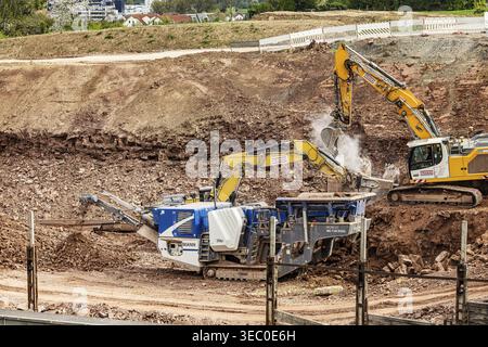 Steinbrecher. Baumaschine und Bagger auf der Dauerbaustelle an der Autobahn A8 bei Pforzheim-Ost bei Niefern-Oeschelbronn. Stockfoto