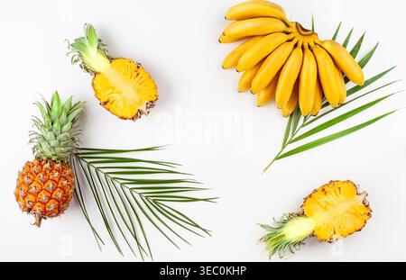 Sommerkomposition mit exotischen Früchten und tropischen Blättern auf weißem Hintergrund. Konzept der gesunden Ernährung. Draufsicht mit Kopierbereich. Stockfoto