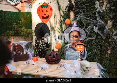 Zwei Kinder tragen Hexenkostüme während einer Halloween-Party im Garten Stockfoto