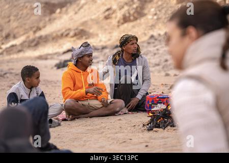 Marsa alam, ägypten 21. april 2026: beduinen sitzen auf Sand, teilen sich ein Lagerfeuer am Abend, führen Gespräche, erleben traditionelle Kultu Stockfoto