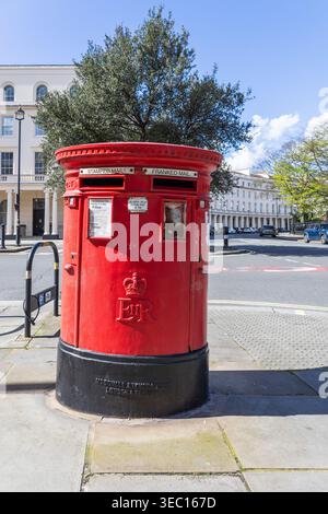 Klassischer roter britischer Briefkasten an einer Straßenecke der Stadt. London, Vereinigtes Königreich, 1. April 2024 Stockfoto