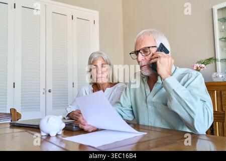 Ein Seniorenpaar beschäftigt sich mit der Altersvorsorge und dem finanziellen Schutz und überprüft wichtige Dokumente zu Hause. Stockfoto