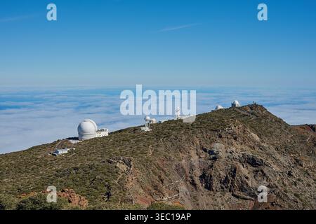 La Palma Observatorien Roque de los Muchachos Observatorien zur Erkundung des Weltalls auf dem Roque de los Muchachos auf La Palma. Die Observatorien stehen auf dem Gipfel des Berges oberhalb der Wolken und sind nicht von Lichtverschmutzung betroffen. Das erste Weltraumteleskop wurde dort 1985 errichtet. Es ist das Gran Telescopio Canarias AGB. Seit dem haben viele Nationen dort verschiedene Arten von Weltraumteleskopen und Observatorien errichtet, oft in Kooperation. Im Bild: Links das William Herschel Telescope WHT 27.1.2025 *** La Palma Observatories Roque de los Muchachos Observatories for Stockfoto