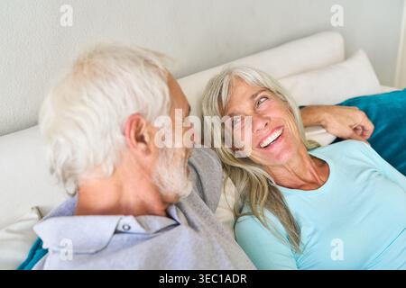 Gesundes Altern und Seniorenleben. Ein glückliches älteres Paar wird gezeigt, wie es sich im Bett entspannt und einen Moment der Gesellschaft und des Wohlbefindens teilt. Stockfoto
