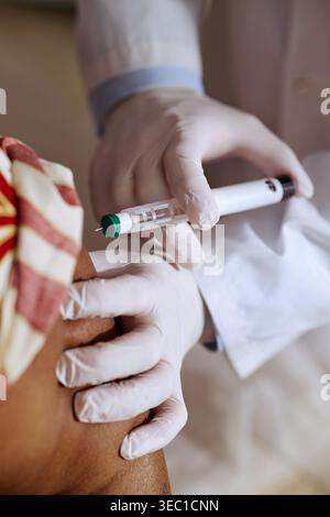 Vertikal des medizinischen Mitarbeiters bei der Insulininjektion in der Klinik Stockfoto