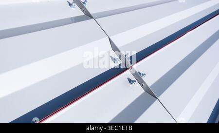 Metallbolzen und -Mutter verbinden ein Wellblech aus Metall Stockfoto