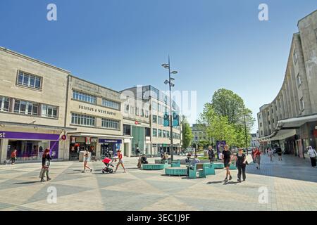 Shopper ruhen sich in der Aprilsonne auf dem kürzlich fertiggestellten Old Town Square auf der Spitze der New George Street Plymouth aus Stockfoto