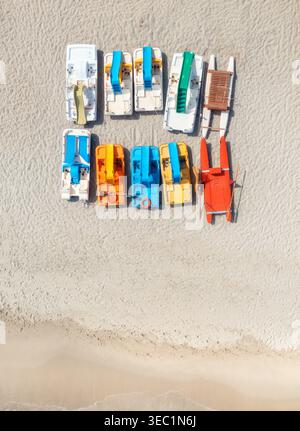 Blick aus der Vogelperspektive auf farbenfrohe Katamarane am leeren Sandstrand Stockfoto