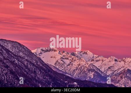 Schneebedeckte Berggipfel leuchten bei Sonnenuntergang in Tombal, Lombardei, Italien Stockfoto