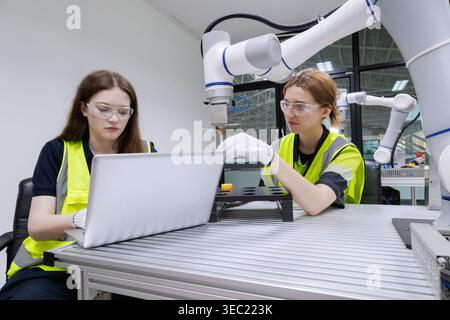 Ingenieurin für Automatisierungsmaschinen studieren und kontrollieren Roboterarmmaschine in der Robotik-Ingenieurakademie an Universitäten oder Fabrikwor Stockfoto