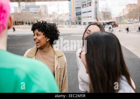 Junge multirassische Gruppe von Freunden, die zusammen in der Stadt lachen Stockfoto