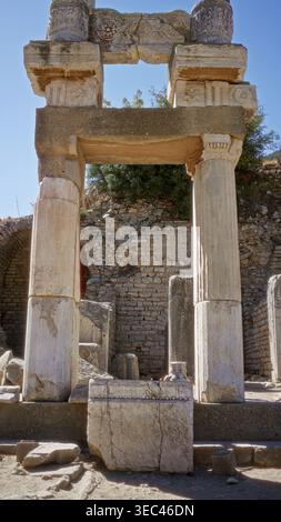 Junge Frau, die in einem offenen antiken Gebäude in ephesus, türkei, steht und auf Marmorruinen blickt; Geschichte bewundert. Stockfoto
