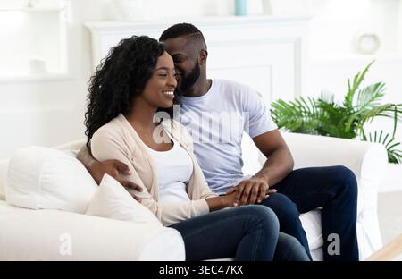 Paare genießen einen gemütlichen Moment zusammen in einem hellen Wohnzimmer Stockfoto