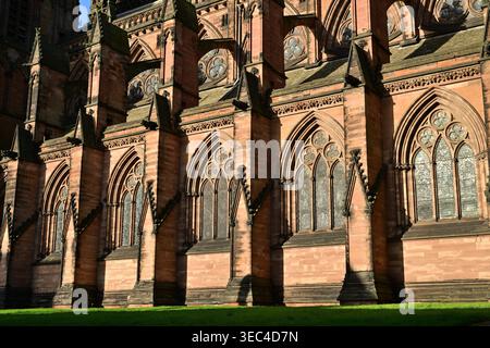 Gotische Kathedralfassade mit Buntglasfenstern und sonnendurchflutetem Stein Stockfoto
