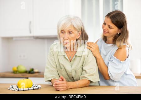 Eine Frau tröstet ihre depressive ältere Mutter Stockfoto