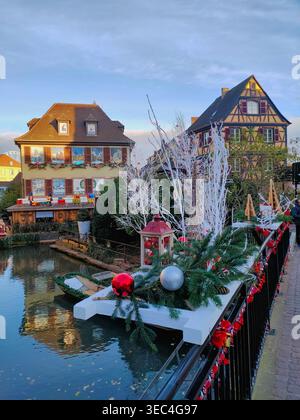 Weihnachtsdekoration neben einem malerischen Kanal mit traditionellen Fachwerkhäusern in Little Venice, Colmar, Elsass, Frankreich. Stockfoto