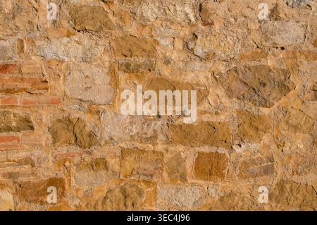 Textur einer rustikalen alten Mauer aus warmem Sandstein und Erdziegeln Stockfoto