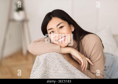 Gerne asiatische Mädchen entspannen im Wohnzimmer Stockfoto