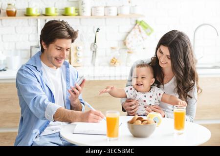 Die Familie genießt das gemeinsame Frühstück in einer gemütlichen Küche und feiert gleichzeitig die gute Zeit Stockfoto