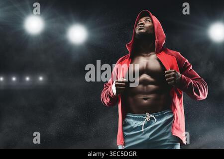 Athlet, der sich auf den Wettkampf in einer dunklen Arena mit hellen Lichtern vorbereitet Stockfoto