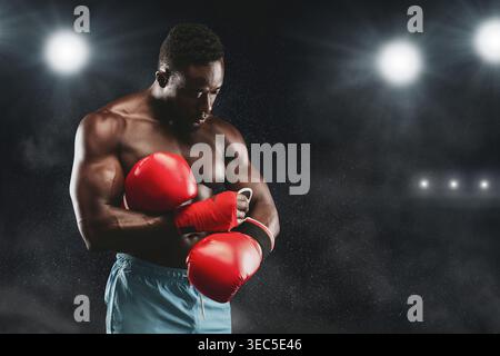 Strong Boxer bereitet sich auf ein Spiel in einer dramatischen Sportarena vor Stockfoto