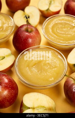 Frische hausgemachte Apfelsauce in Glasschüsseln mit roten Äpfeln Stockfoto