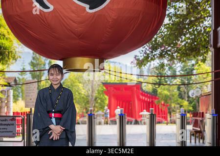 Chiang Dao, Thailand - 29. Januar 2026: Eine fröhliche Thai-Frau in traditioneller japanischer Kleidung lächelt die Kamera an und steht an den Drehkreuzen am Eingang Stockfoto