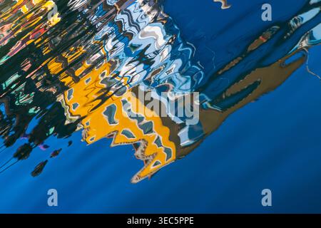 Abstrakte Reflexionen Burano Venedig Italien. Farbenfrohe Kanalmuster schaffen lebendige Texturen und künstlerische Hintergründe aus venezianischen Häusern. Stockfoto