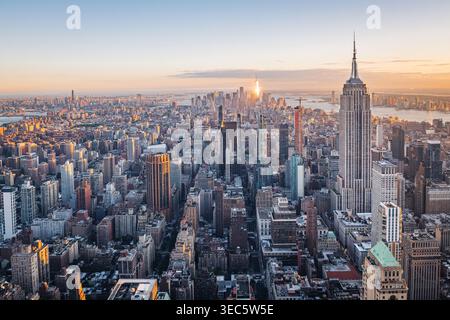 Aus der Vogelperspektive auf das Empire State Building und Downtown Manhattan in der Abenddämmerung, New York City. Dieser atemberaubende Blick fängt den berühmten Wolkenkratzer in der Mitte des Gebäudes ein Stockfoto
