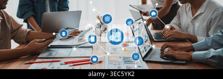 Ein vielseitiges Geschäftsteam arbeitet an wichtigen Leistungsindikatoren mit Laptops und visuellen Datendiagrammen in einer hellen und modernen Büroumgebung zusammen Stockfoto