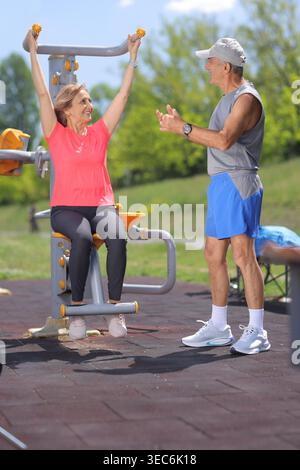 Senior Mann, der mit einer Frau in einem Fitnessstudio spricht Stockfoto