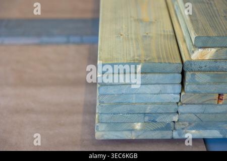 Gestapelte Holzbretter in Innenräumen, vorbereitete Materialien für den Bau oder die Installation. Konzept: Lagerung und Vorbereitung von Holz Stockfoto