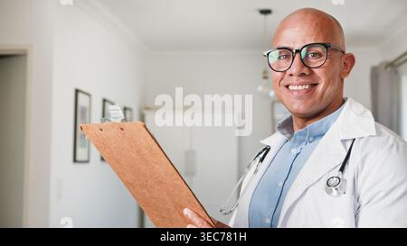 Lächelnder Männlicher Arzt Mit Clipboard Und Stethoskop-Porträt Im Medizinischen Büro, Der Patient Besucht Stockfoto