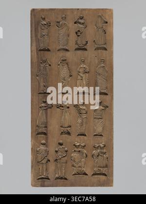 Doppelseitige Lebkuchenform; Vorderseite: 16 Bilder verschiedener Figuren; Rückseite: 12 Abbildungen. Doppelseitige rechteckige Form; auf einer Seite 16 kleine Bilder, die verschiedene menschliche Figuren, männlich und weiblich, in vier gleichen Reihen angeordnet, von vorne und von hinten dargestellt. Die andere Seite: Zwölf Elemente, darunter zwei männliche Figuren auf einem Hahn, eine andere in Bauernkostüm, dargestellt in zwei Ansichten vorne und hinten; vier verschiedene Kleidungsstücke; zwei Pfeifen mit Quasten verziert; und zwei Vögel, die auf einem mit Blumen gefüllten Krater sitzen; eine Säule mit einer Blumengirlande mit zwei Vögeln auf Stockfoto