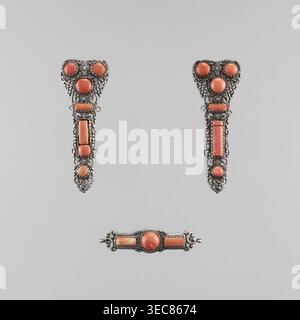Ein Satz von Flechtschmuck, bestehend aus einer schließe und zwei Anhängern, Ende des 18. Jahrhunderts, mongolischer Herkunft; Damenflechtschmuck als Schmuck, künstlerische Handwerkskunst; Abmessungen: Höhe 10,0 cm, Breite 13,0 cm., Eine Gruppe dekorativer Metallstücke, die auf einem hellgrauen Hintergrund stehen, jedes Stück mit verzierten silbernen Filigranen und einigen runden und länglichen korallenfarbenen Steinen; zwei vertikal ausgerichtete Stücke mit herzförmigen Spitzen zeigen komplexe Silbermuster um runde und rechteckige Korallensteine und einige kleine kreisförmige Akzente, während ein separates horizontales Stabstück darunter liegt Stockfoto